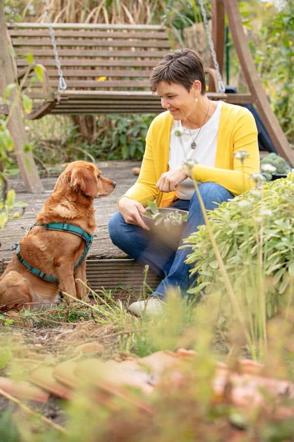 ASG_3098 Kopie Katrin Schäfer – Ernähungstherapeutin und Coach – sitzt im Garten mit ihrem Hund