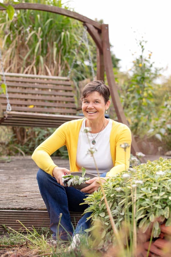 ASG_3105 Kopie Katrin SchĂ€fer â ErnĂ€hrungstherapeutin & Coachin sitzt im Garten auf der Holzterrasse