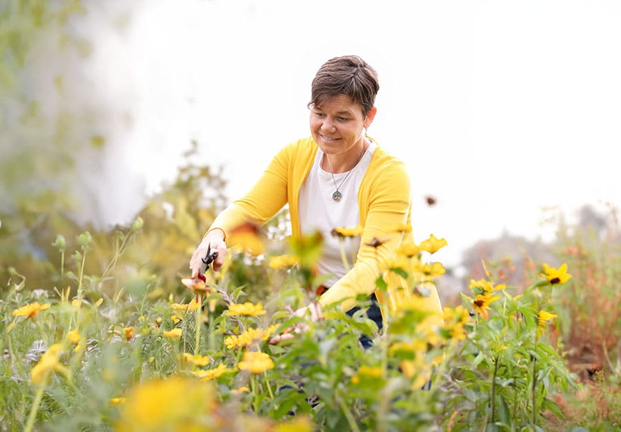kontakt-katrin-header-mobil Ernährungsberaterin Katrin Schäfer schneidet Blumen im Garten